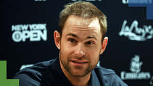 Professional Tennis Player Andy Roddick Smiling During An Interview Wallpaper