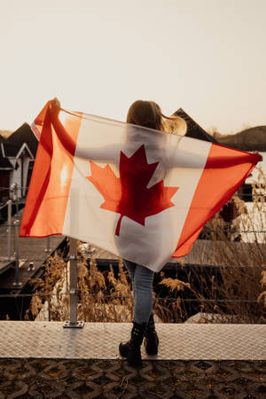 Proud Canadian Woman Holding National Flag Wallpaper