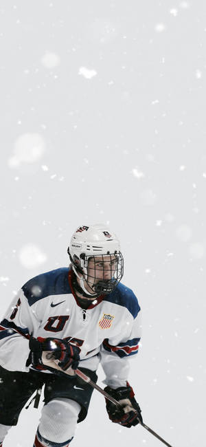 Quinn Hughes Holding Hockey Stick And Playing For Team Usa Wallpaper