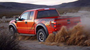 Red Lifted Truck Driving On Desert Wallpaper