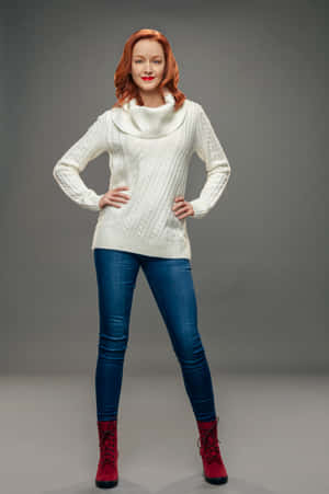 Redhead Womanin White Sweaterand Blue Jeans Wallpaper