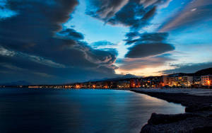 Rhythmic Waves Under Starry Night At Rethymno Beach Wallpaper