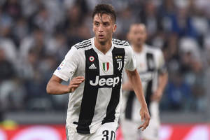 Rodrigo Bentancur For Juventus Running On Field Wallpaper