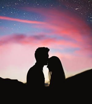 Romantic Couple Forehead Kiss Under Pink Skies Wallpaper