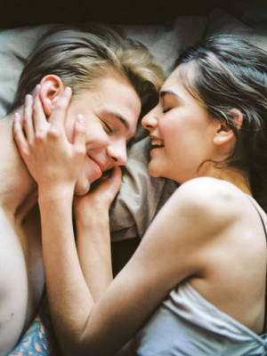 Romantic Couple Morning Smiles In Bed Wallpaper