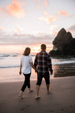 Romantic Couple Walking On The Shore Wallpaper