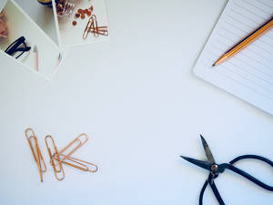Rose Gold Clips And A Pen Wallpaper