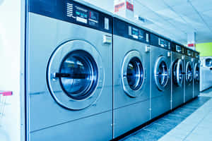 Rowof Industrial Washing Machinesin Laundromat Wallpaper