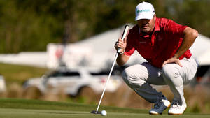 Ryan Palmer Squatting Looking At Ball Wallpaper