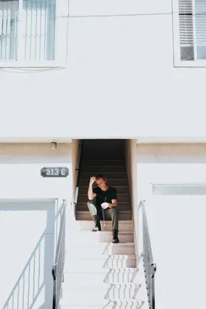 Sad Alone Lad On Staircase Wallpaper