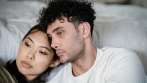 Sad Couple Leaning On Bed Wallpaper