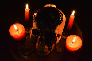 Scary Skulls And Lit Candles Wallpaper
