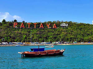 Scenic View Of A Traditional Boat Docking In Pattaya City Wallpaper
