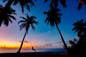 Serene Seaside With A Gleaming Sunset Wallpaper