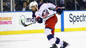 Seth Jones Gliding On Ice While Waving Hockey Stick Wallpaper