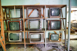 Shelf Of Television Sets With Cracked Screen Wallpaper