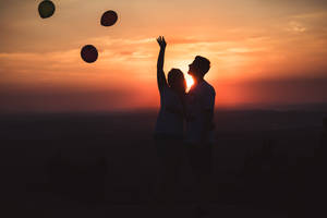 Silhouette Couple Releasing Balloons Wallpaper