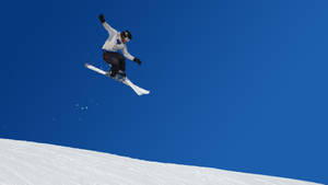 Ski Jumper Mid-air In A Majestic Winter Environment Wallpaper