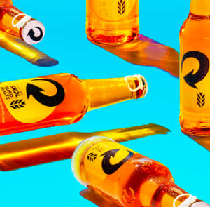 Skol Beer Bottles Floating Against Blue Background Wallpaper