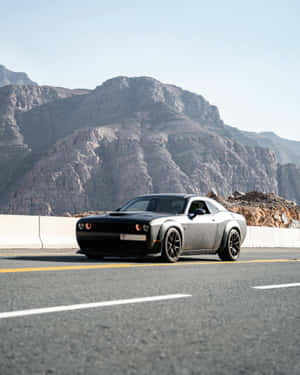 Sleek Black Car Mountain Road Wallpaper