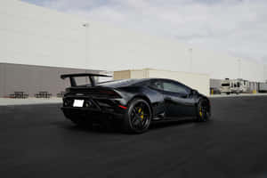 Sleek_ Black_ Sports_ Car_ Parked_ Outdoors.jpg Wallpaper