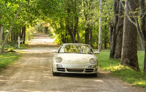 Small Luxury Car On Country Road Wallpaper