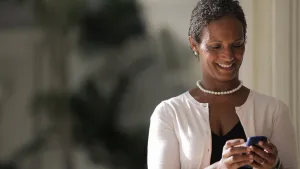 Smiling Middle Aged Woman Using Smartphone.jpg Wallpaper