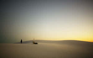 Solitary Desert Walkat Sunset Wallpaper