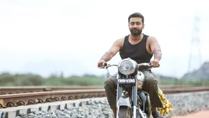 Soorarai Pottru Suriya On Motorcycle Near Tracks Wallpaper