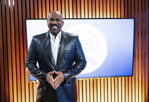 Steve Harvey Smiling In A Leather Suit Wallpaper