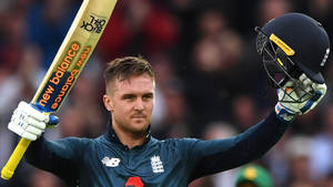 Striking Powerhouse - Jason Roy With Bat And Helmet In Action Wallpaper