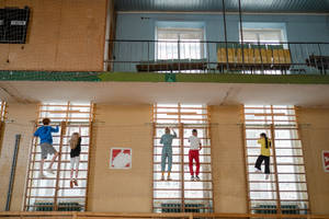 Student Scaling A Climbing Wall In Physical Education Class. Wallpaper