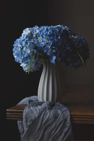 Stunning Vase Of Blue Flowers For Phone Screens Wallpaper