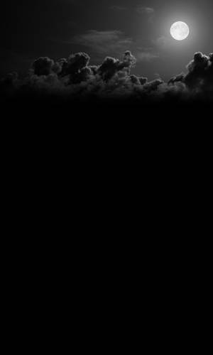 Stunning View Of A Full Moon Behind Gray Clouds On A Night Sky Wallpaper