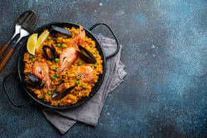 Sumptuous Paella Dish In Traditional Spanish Pan Wallpaper