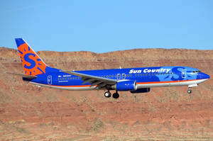Sun Country Airplane Above Canyon Wallpaper