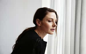 Swedish Actress Rebecca Ferguson Looking Out A Window Wallpaper