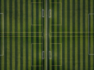 Take Control Of The Game On The Striped Football Field Wallpaper
