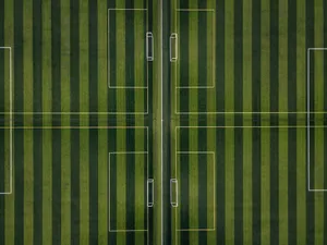 Take Control Of The Game On The Striped Football Field Wallpaper