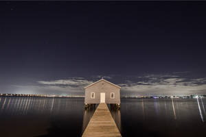 Take In The Beautiful View Of A House On A Tranquil Body Of Water. Wallpaper