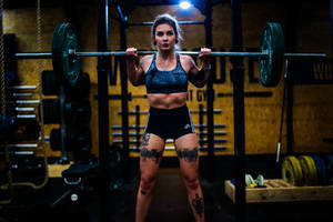 Tattooed Weightlifter At The Gym Wallpaper