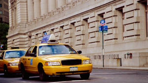 Taxi At The Side Of Classical Building Wallpaper