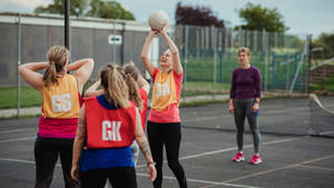 Teenage Girl Preparing To Score A Netball Goal Wallpaper