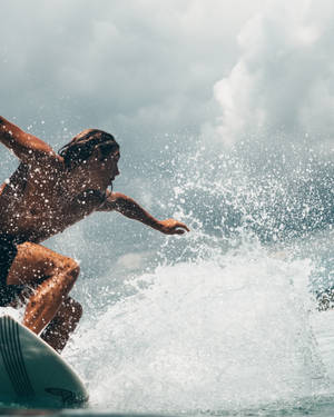 Tenacious Surfer On Surfing Board Wallpaper