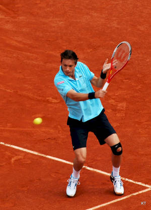 Tennis Champion Nicolas Mahut Exhibit Superior Skills On Orange Court Wallpaper