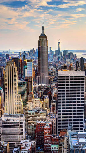 The Big Apple Skyline Illuminated Against The Night Sky Wallpaper