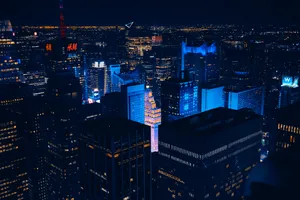 The Bustling City Of New York Glows With Blue Light. Wallpaper