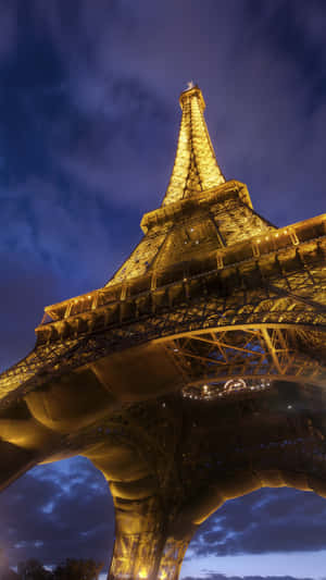 The Eiffel Tower Is Lit Up At Night Wallpaper