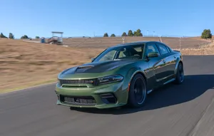 The Green 2019 Dodge Charger Srt Driving On A Race Track Wallpaper