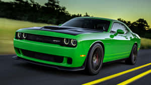 The Green Dodge Challenger Is Driving Down The Road Wallpaper
